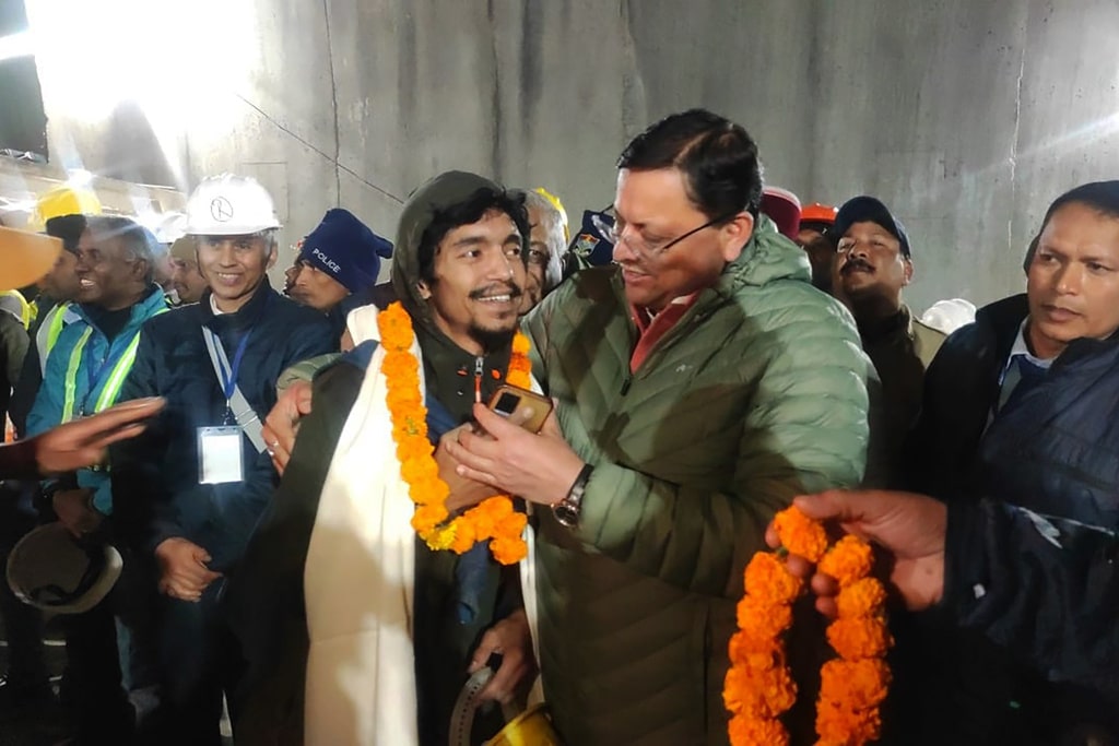 Pushkar Singh Dhami, right, Chief Minister of the state of Uttarakhand, greeting a worker rescued from the site of an under-construction road tunnel that collapsed in Silkyara in the northern Indian state of Uttarakhand, India, Tuesday, Nov. 28, 2023.