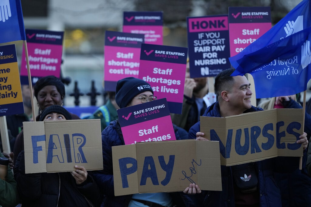 Demonstrators hold up placards in support of a strike by nurses outside St Thomas' Hospital in London