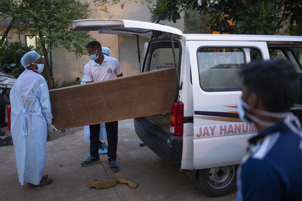Healthcare workers carry the body of a person who died in Friday's train accident in Balasore, into an ambulance at the All India Institute of Medical Sciences hospital in Bhubaneswar in the eastern state of Orissa, India, Monday, June 5, 2023.