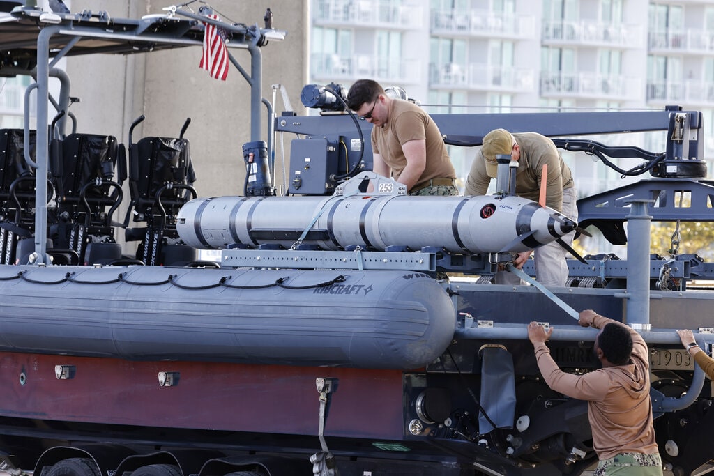 Members of the Navy work on a device on a vessel along the InterCoastal Waterway in North Myrtle Beach, S.C., Tuesday, Feb. 7, 2023. Using underwater drones, warships and inflatable vessels, the Navy is carrying out an extensive operation to gather all of the pieces of the massive Chinese spy balloon a U.S. fighter jet shot down off the coast of South Carolina on Saturday.