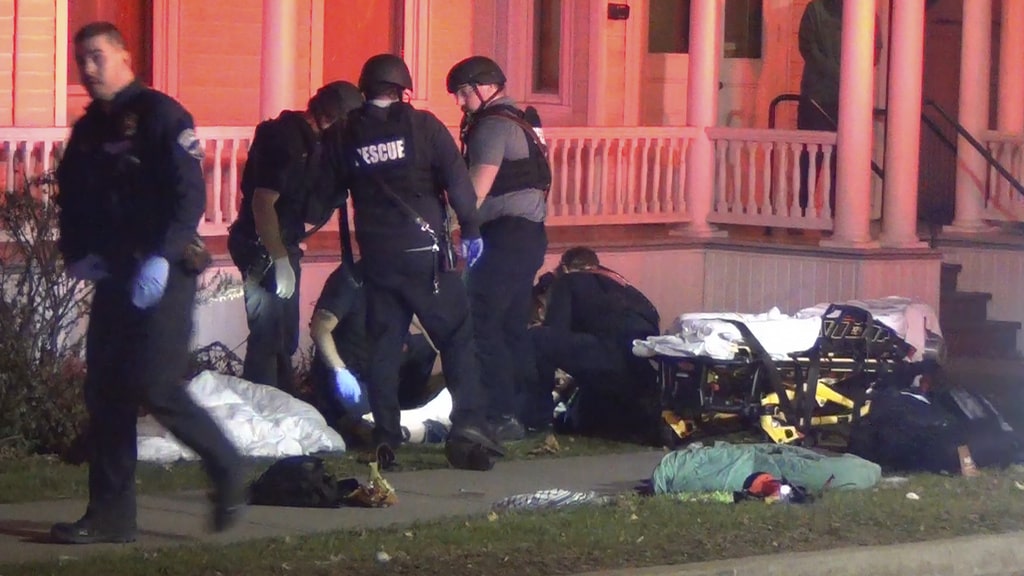 In a still frame from video first responders tend to an injured man, behind, at the scene of a shooting, Nov. 25, 2023, in Burlington, Vt.